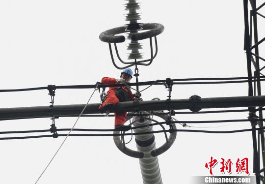 圖為電力工人在70多米高空作業，為特高壓復奉線重慶段進行八年來首次大修。　周毅 攝