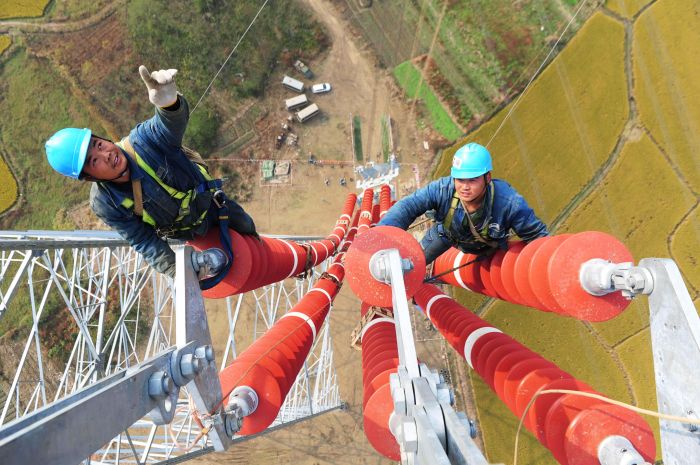 國網安徽電力施工人員在安徽蕪湖市無為縣的70多米高的瓷瓶串上施工。（鄭賢列攝）